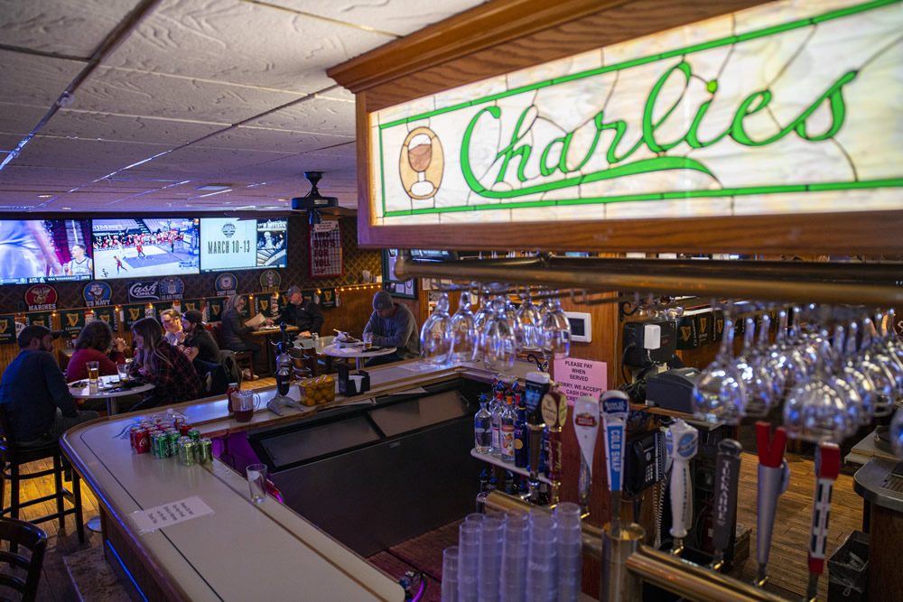 The front bar at Charlie's under the green neon sign
