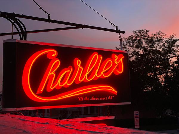 Charlie's in red neon against a summer sunset