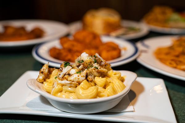 Crabby mac alongside a plate of wings