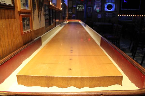 The shuffleboard table, lit and waiting