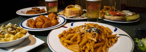 Penne alla vodka, tenders and a burger across the table